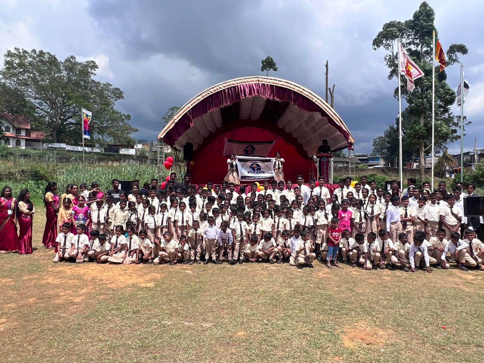 Students and staff gathered for a school assembly on the sports field, presenting the Capricorn College banner.